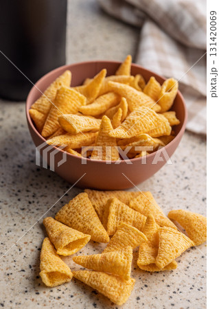 Bugles snack. Cone corn chips on kitchen table. 131420069