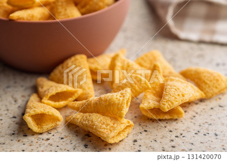 Bugles snack. Cone corn chips on kitchen table. 131420070