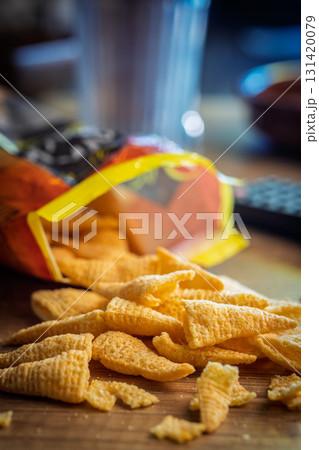 Bugles snack. Cone corn chips on wooden table. 131420079