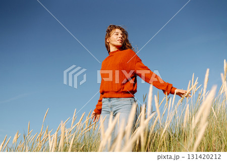 Happy woman enjoying nature outdoors in tall grass. Flying hairs. Outdoor. Fashion style. Happy woman enjoying nature outdoors in tall grass. Flying hairs. Outdoor. Fashion style. 131420212