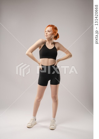 Elegant woman in black attire poses confidently with creative lighting Elegant woman in black attire poses confidently with creative lighting 131420668