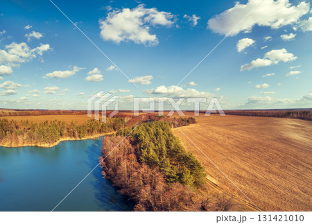 Lakeshore in autumn. View from above of lake and arable field. Nature landscape Nature background Lakeshore in autumn. View from above of lake and arable field. Nature landscape Nature background 131421010