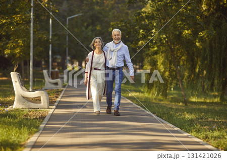 Happy senior couple walking in the park enjoying retirement and spending time together. Happy senior couple walking in the park enjoying retirement and spending time together. 131421026