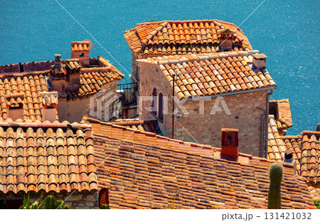 The medieval village of Eze in France. Ancient houses with tiled roofs against the backdrop of the sea 131421032