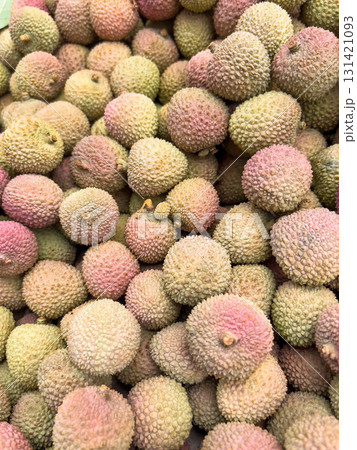 pile of Fresh Lychee Fruits with Rough Pink-Green Skin in Natural Light on market. pile of Fresh Lychee Fruits with Rough Pink-Green Skin in Natural Light on market. 131421093