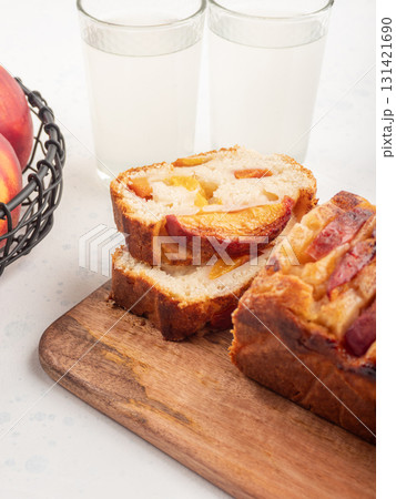 Peach cake loaf on wooden cutting board on white backgroud Peach cake loaf on wooden cutting board on white backgroud 131421690