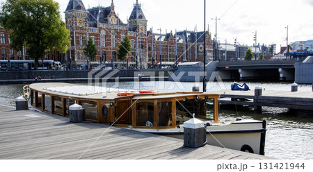 Scenic View of a Tour Boat Docked Near Historic Buildings in the City of Amsterdam 131421944