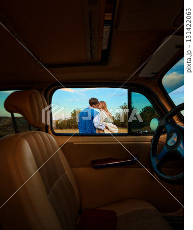 Young couple kissing outdoors framed through vintage car window Young couple kissing outdoors framed through vintage car window 131422063