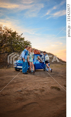 Young travelers with retro car on countryside road during golden sunset 131422077