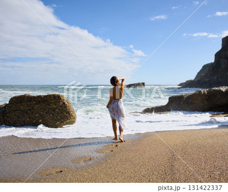 Young woman walking on sandy beach 131422337