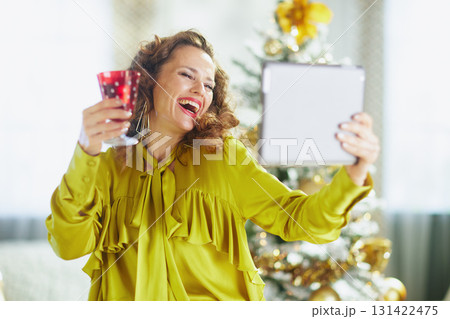 Cheerful Woman Captures Holiday Moment with Tablet 131422475
