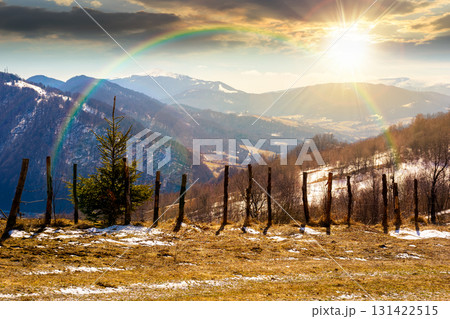 mountainous countryside at sunset. winter to spring season change scenery. melting snow and leafless trees on the rolling hills in evening light. view to the distant valley 131422515