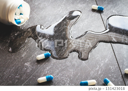 Tablets. Dropping pills and a glass of water from the hands. 131423018