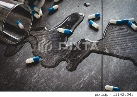 Tablets. Dropping pills and a glass of water from the hands. 131423043