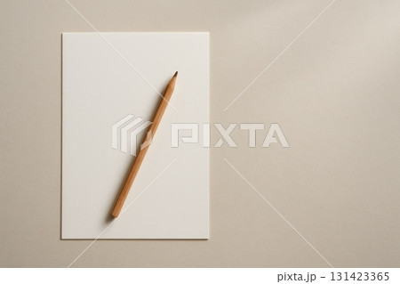 Blank white paper and pencil on beige background. Minimalist design mockup, copy space 131423365