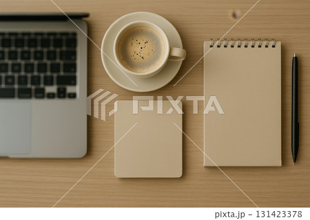 Top view of minimalist workspace with laptop, coffee cup, notepad, and pen on wooden desk, showcasing clean design. 131423378
