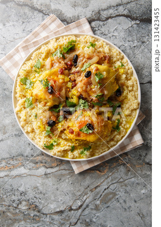 Savory sweet fragrant chicken couscous tfaya is a comforting and special meal closeup on the plate. Vertical top view Savory sweet fragrant chicken couscous tfaya is a comforting and special meal closeup on the plate. Vertical top view 131423455