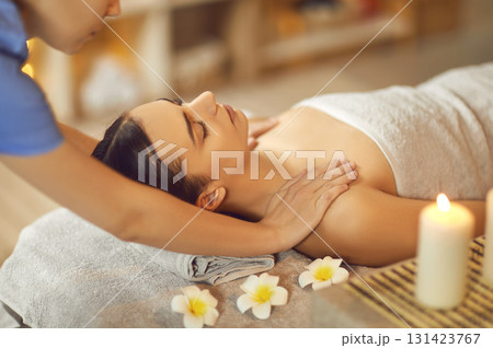 Beautiful young woman with closed eyes relax in spa salon getting massage. Beautiful young woman with closed eyes relax in spa salon getting massage. 131423767