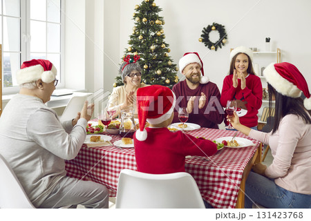Joyful family sitting around table, eating Christmas dinner and having fun together Joyful family sitting around table, eating Christmas dinner and having fun together 131423768