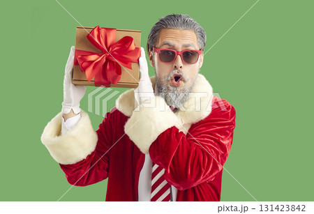 Portrait of a funny surprised young man dressed in a Santa Claus costume. 131423842