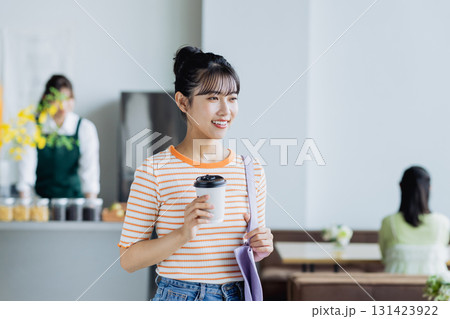 カフェでコーヒーを買う若い女性 カフェでコーヒーを買う若い女性 131423922
