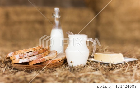 milk in a jug, slices of wheat bread and butter on hay milk in a jug, slices of wheat bread and butter on hay 131424688