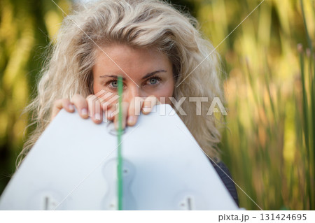 Stylish blonde surfing girl holding white surfboard in jungle on Bali. Close-up woman portrait, perfect for exotic travel content, freedom lifestyle, surf destinations in tropical islands destinations Stylish blonde surfing girl holding white surfboard in jungle on Bali. Close-up woman portrait, perfect for exotic travel content, freedom lifestyle, surf destinations in tropical islands destinations 131424695