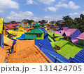 Aerial view of vibrant rooftops in Kampung Warna Warni Jodipan, Malang, East Java, Indonesia. Famous rainbow village, perfect destination for urban tourism, travel blogging, and cultural exploration. 131424705