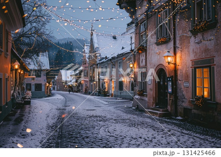 Winter street scene with charming buildings illuminated by festive lights and snow-covered ground 131425466
