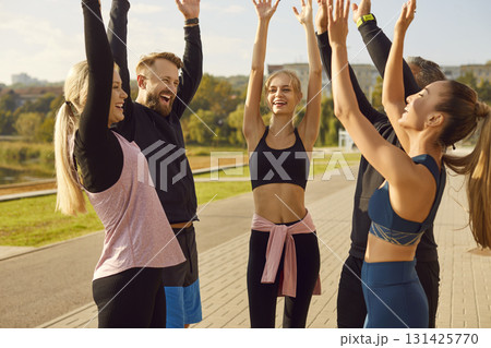 Team Of Athletes Training Together In A Park With Raised Hands 131425770