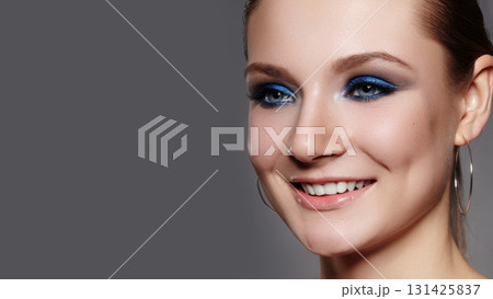 Closeup Macro of Beautiful Smiling Woman Face with Blue Eyes Make-up. Fashion Celebrate Makeup, Glowy Clean Skin, perfect Shapes of Brows. Shiny Simmer and Rouge 131425837