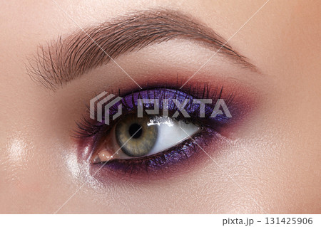 Macro of bright purple eye make-up. Celebrate Makeup for fashion show, bride wedding style. Perfect for Beauty salon, Makeup Artist or Cosmetic store Advertising. Glowy Skin, perfect brows shapes Macro of bright purple eye make-up. Celebrate Makeup for fashion show, bride wedding style. Perfect for Beauty salon, Makeup Artist or Cosmetic store Advertising. Glowy Skin, perfect brows shapes 131425906
