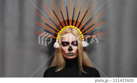 Creative Santa Muerte style portrait with purple Sugar Skull Makeup, tiara, and floral headdress. Fantasy art, mysterious glamour, gothic allure, surreal inspiration, divine feminine expression 131425920