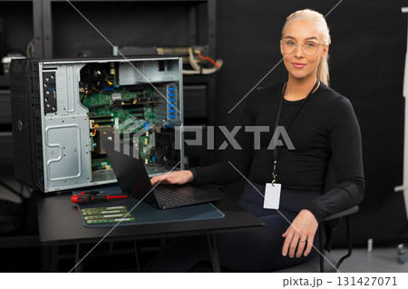 Female IT technician in a data center repairing server hardware with laptop and tools Female IT technician in a data center repairing server hardware with laptop and tools 131427071