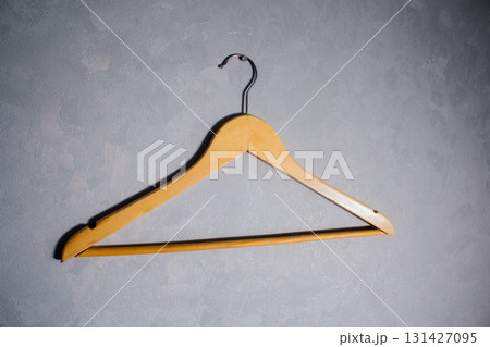 Wooden clothes hanger with metal hook. Concept of simplicity and home organization 131427095