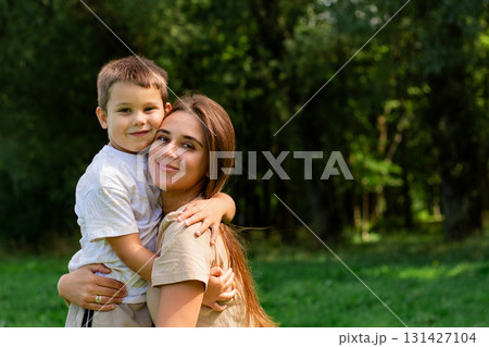 Candid portrait of mom and son hug and kiss. Lifestyle, tender relationship of young mother and child, happy family and motherhood. Candid portrait of mom and son hug and kiss. Lifestyle, tender relationship of young mother and child, happy family and motherhood. 131427104