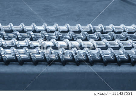 Close up scene body of the barrel screw of injection machine spare parts in the light blue scene. 131427551