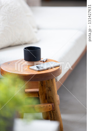 木製のスツールに置かれたスマートフォンとコーヒーカップ 131427631