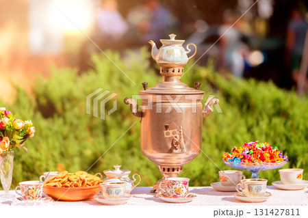 Traditional Russian samovar with cups and sweets on the table. 131427811