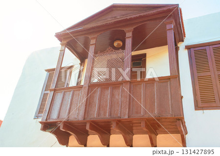 Wooden vintage open balcony in Greek or Turkish style against white building wall background. Wooden vintage open balcony in Greek or Turkish style against white building wall background. 131427895
