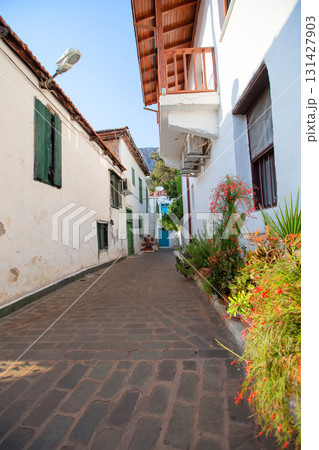 Narrow tourist streets of the Turkish city of Kas with white houses and colored windows. Beautiful ethnic resort town. 131427903