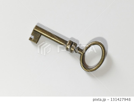 Old brass key shown on a plain white surface Old brass key shown on a plain white surface 131427948