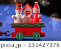 Christmas toy wooden red retro train decorated with children's snowmen and Christmas trees. 131427976
