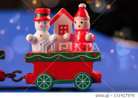 Christmas toy wooden red retro train decorated with children's snowmen and Christmas trees. 131427976