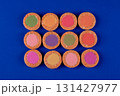 A row of colorful cookies with a blue background. The cookies are in a row and are of different colors 131427977
