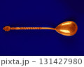 Golden teaspoon on a blue background. 131427980