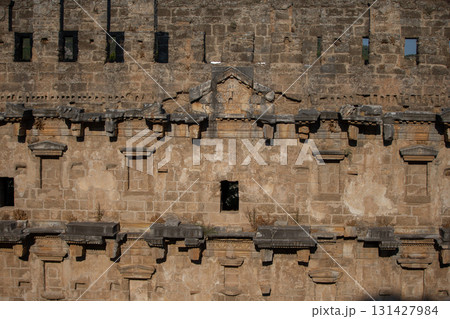 Part of the stone wall of the ancient amphitheater with architectural elements. 131427984
