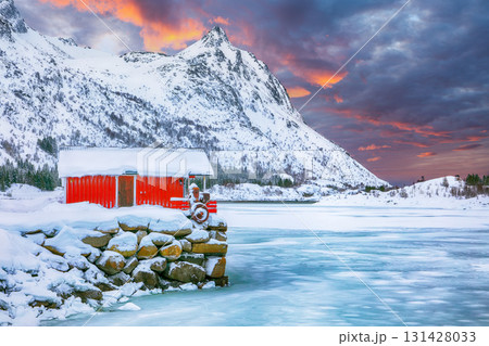 Unbelivable winter scenery with traditional Norwegian red wooden houses on the shore of Rolvsfjord. 131428033
