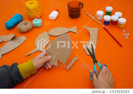 Make a fish sculpture from cardboard, thread, and paint, following step-by-step instructions, with an orange background. 131428281