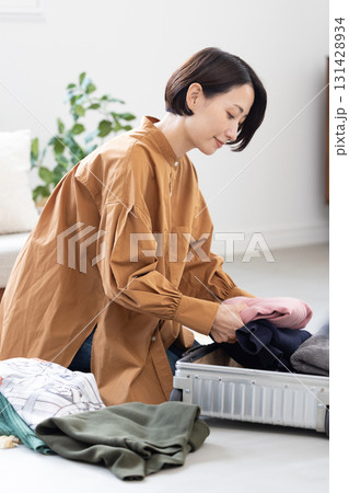 スーツケースに衣類を詰める女性 スーツケースに衣類を詰める女性 131428934